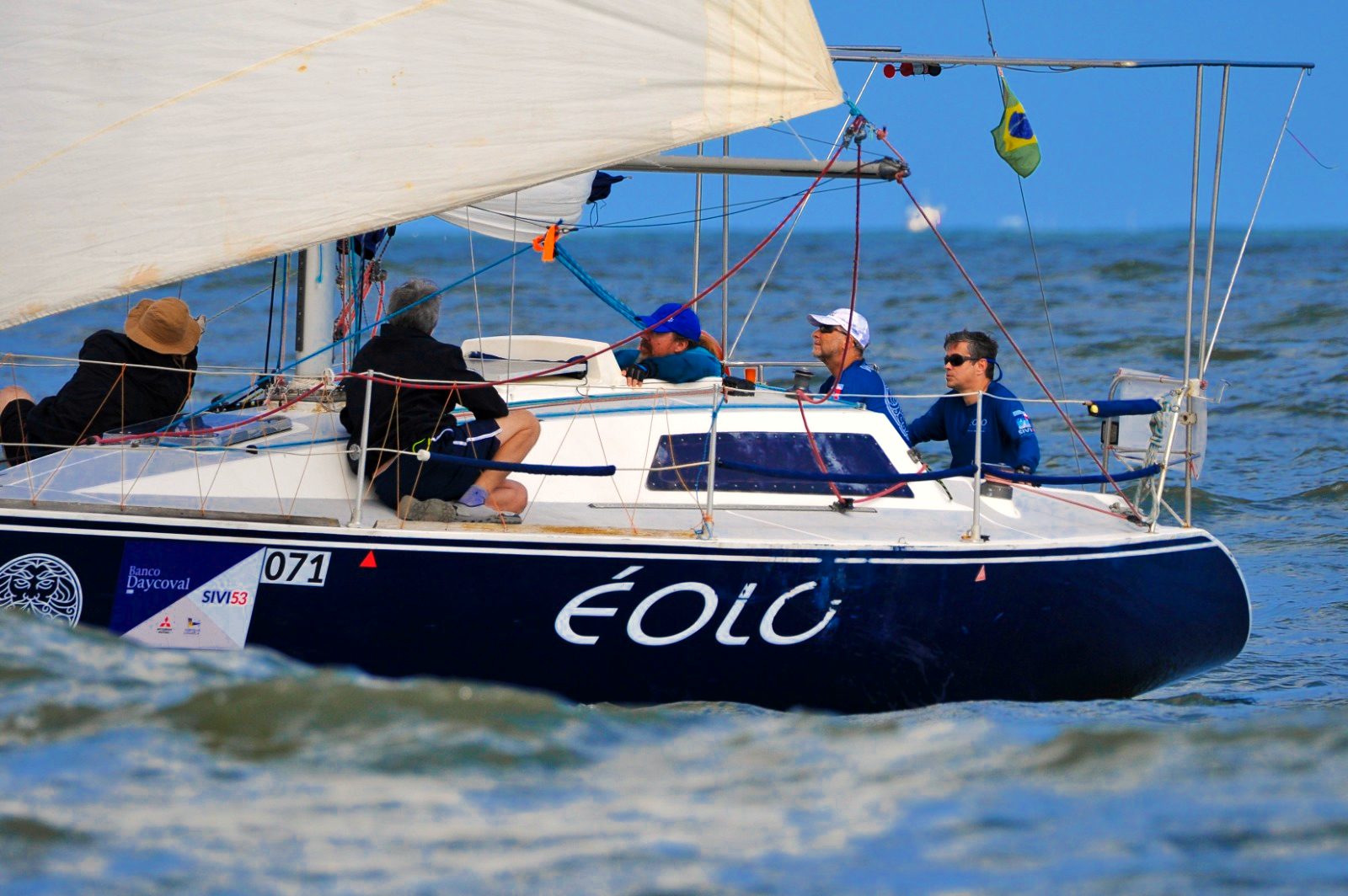 O Éolo em regata, inclinado pelo vento, com a tripulação a bordo